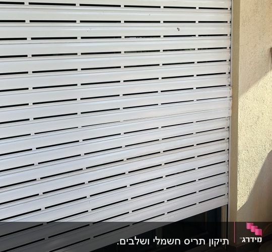 תריס גלילה לבן על קיר חיצוני